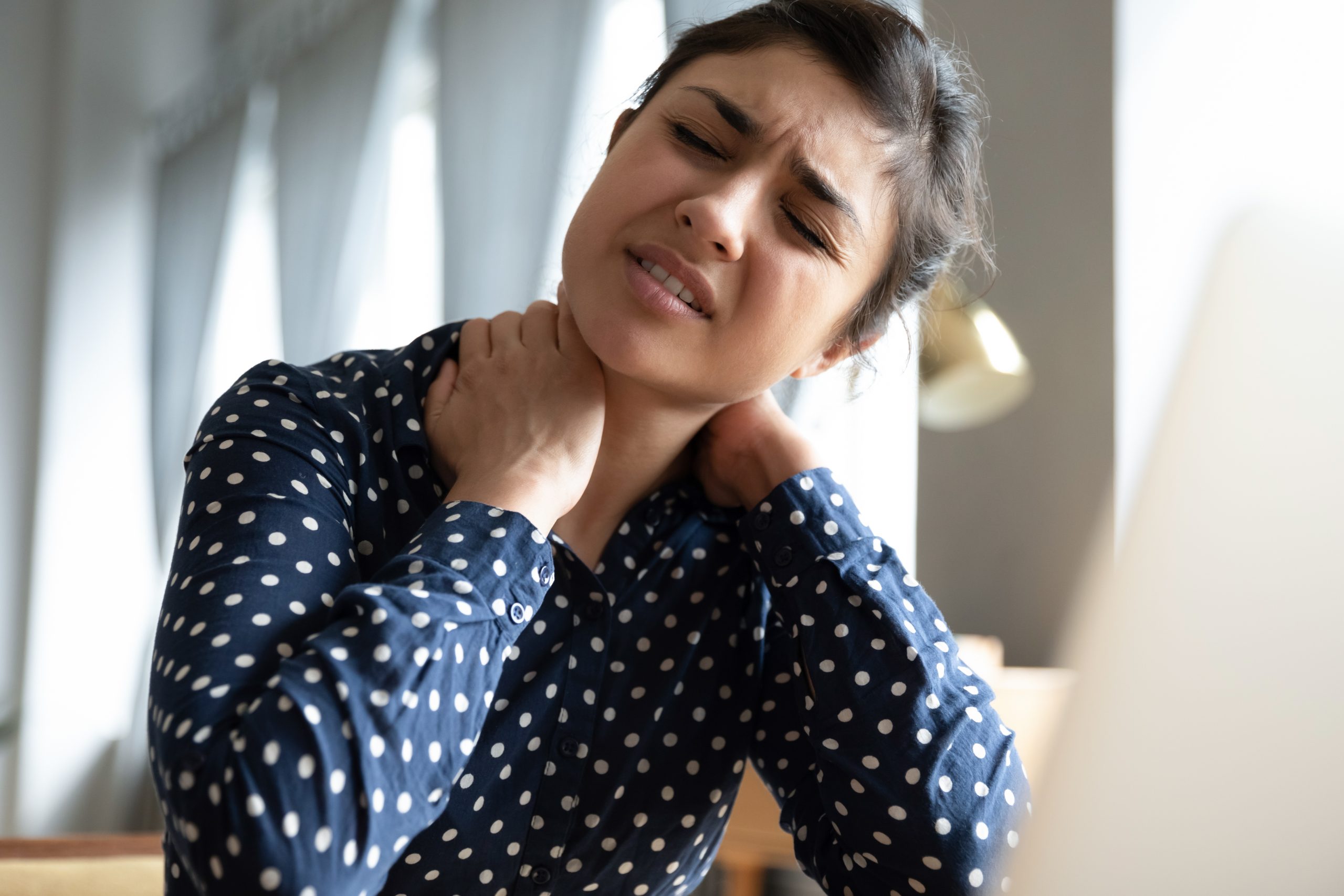 Unhappy Indian girl massaging stiff neck muscles close up stem cell injections can loosen tight muscles